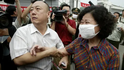 Getty Images A woman leaves Xiaotangshan after being treated for SARS