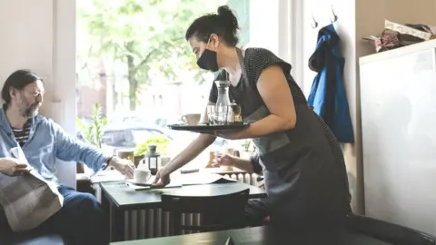 Getty Images Bar worker wearing mask