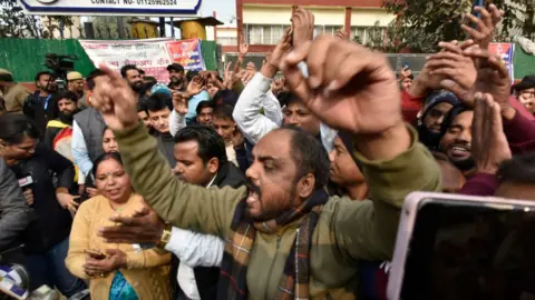 Getty Images Hundreds of people gathered outside the Sultanpuri police station, demanding strict action against the five men who were in the car that crashed into the scooter of the woman, on January 2, 2023 in New Delhi, India.