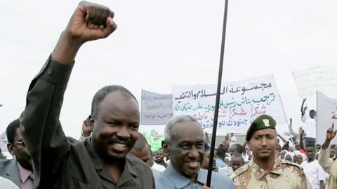 Getty Images Haroun (left) in 2010 when he was governor of the South Kordofan region