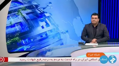 News presenter in front of blue globe graphic on Iranian state TV
