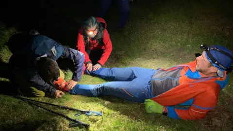 Ross Jenkin Two people tend to Mr Jenkin's feet