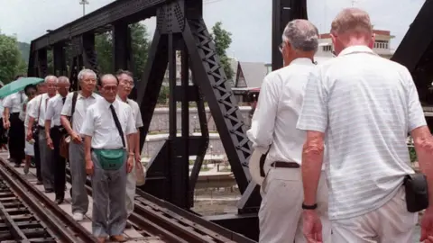 Getty Images Two Australian former prisoners of war (R) march across the famous bridge over the River Kwai to meet with the Japanese lead group of war veterans 15 August in Kanchanaburi, western Thailand, to mark the 50th anniversary of the end of World War II