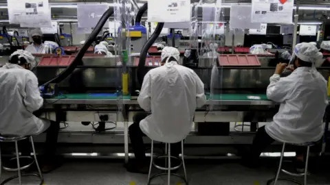 Getty Images Workers at a mobile factory in Noida