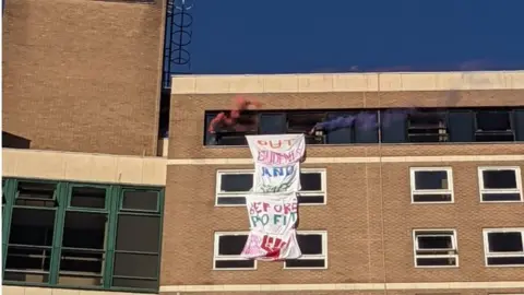 Tower occupiers  Put students and staff before profits banner