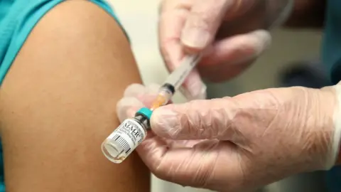 Getty Images A health professional prepares to vaccinate someone against measles in Auckland