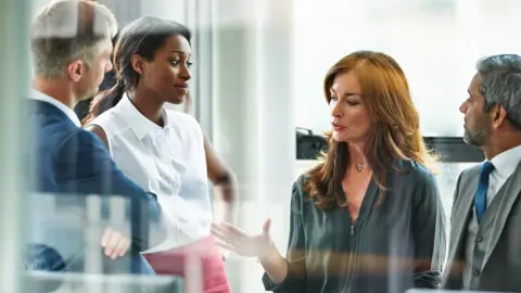 Getty Images Female business executive leading team meeting