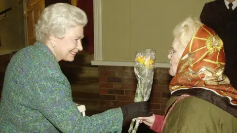 PA Media The Queen receiving flowers from Dorothy Cornwell