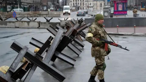 Reuters A member of the Territorial Defence Forces guards a checkpoint, as Russia"s invasion of Ukraine continues, at the Independence Square in central Kyiv,