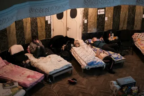 Refugees rest in a shelter in a small theatre in Lviv. By early evening on Sunday the shelter was full and turning people away.