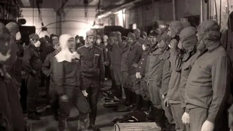 Getty Images Firefighters pictured before going on the roof of reactor No. 4 to clean radioactive debris