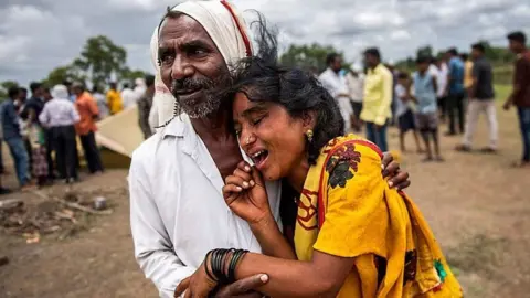 Getty Images Man hugging a distressed woman