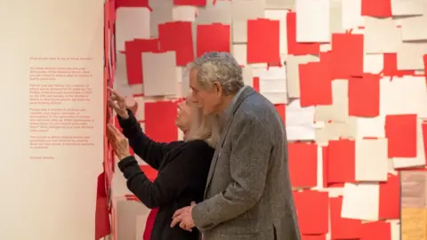 Joe Gibson Two people looking at a wall of letters