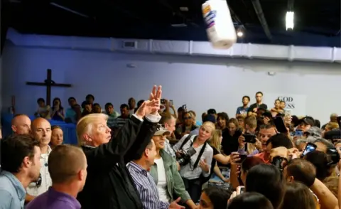 Reuters Trump tosses rolls of paper towels into the crowd