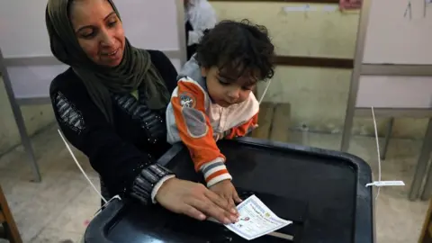 Reuters Egyptian woman and her child cast a ballot in the presidential election in Cairo on 26 March 2018