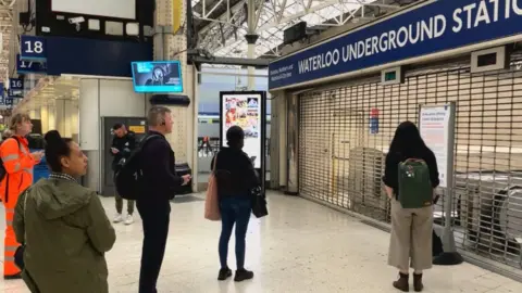 BBC People standing outside a close Waterloo station Tube entrance