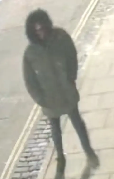 Crimestoppers CCTV image of person wearing parka-style coat with hood up