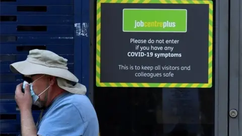 Reuters Man walks past Job Centre office