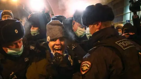 Getty Images Police detain a Navalny supporter at Vnukovo airport, 17 Jan 21