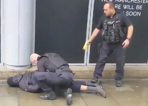 JOHN GREENHALGH Officers with an arrested man