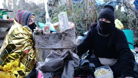 Activists Anna (L) and Kim have been at the site for a week and are now chained to a barrel filled with concrete