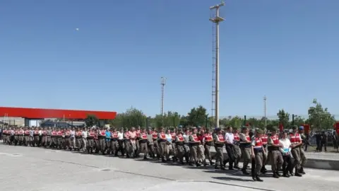 AFP The line of defendants arriving for their trial (01 August 2017)