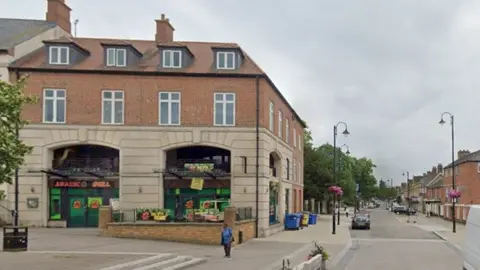 Google Three-storey brick and stone building in corner of Market Place with dinosaur-themed window dressing