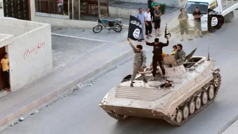 Reuters Islamic State militants take part in a military parade along the streets of Raqqa, Syria, on 30 June 2014