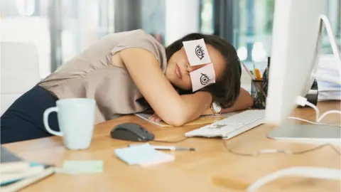 PeopleImages Woman asleep at desk