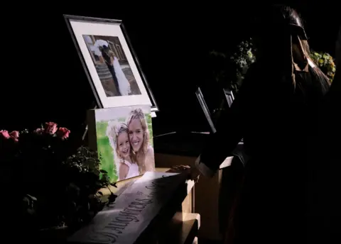 Getty Images A girl looks at the coffins with the remains of Rhonita Miller and four of her children