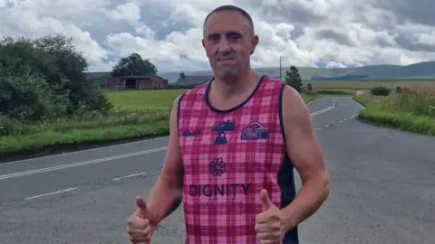 Ben Moorhouse Ben Moorhouse walking along a country road