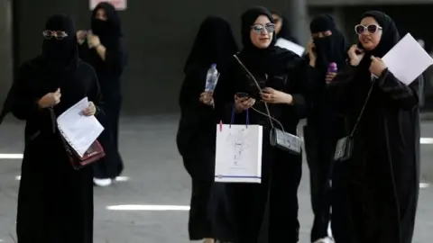 Reuters Women walk among traffic in Riyadh (file photo)