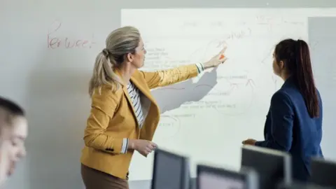 Getty Images Teacher pointing at whiteboard