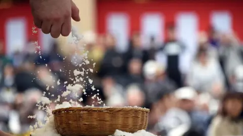 AFP/Getty A wrestler grabs a handful of salt from a basket