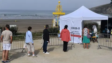 Getty Images People wait to be tested at a mobile test centre on a beach in western France,