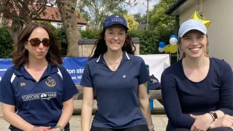 Three female cricketers at the unveiling of the changing rooms