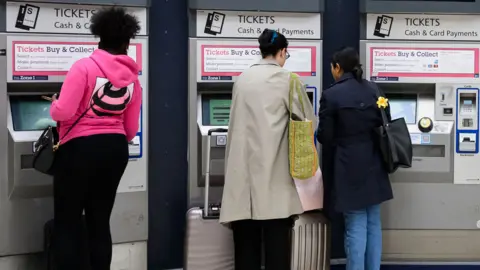 Getty Images Passengers purchase rail tickets from self-service machines in Victoria Station on 5 July 2023 in London, England