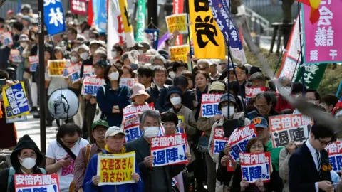 EPA Protesters hold placards outside the National Diet Building during a protest against Japanese Prime Minister Shinzo Abe's cabinet in Tokyo, Japan, 13 March 2018