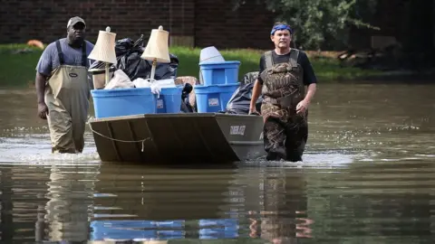 Getty Images two men rescue contents of house from flood