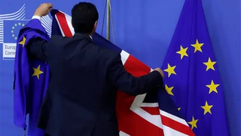 Reuters Official arranges UK and EU flags at EU Commission HQ