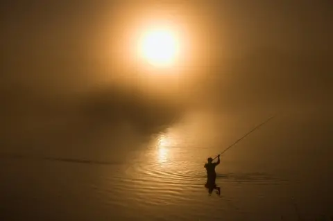 Fishing Rod Wheel Fisherman Fishing Spinning On Canal At Sunset