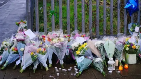 Ben Birchall/PA Floral tributes to Max Dixon and Mason Rist on Ilminster Avenue in Knowle West