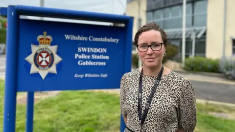 BBC Det Supt Sarah Robbins stands in front of a sign at Gable Cross Police Station in Swindon