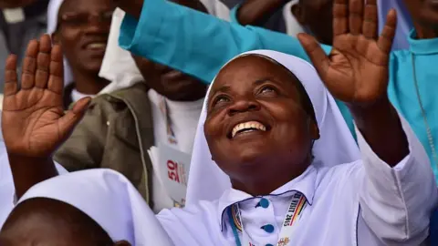 Getty Images A nun reacts at Namugongo Martyrs' Shrine during an open air mass held by Pope Francis on November 28, 2015