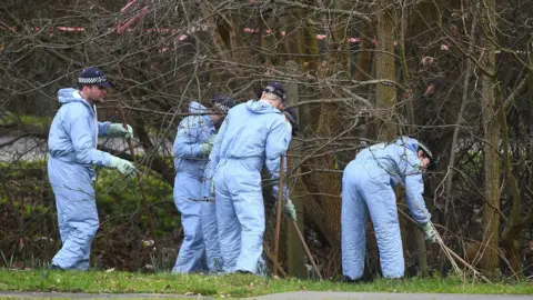 PA Forensic officers by trees near crime scene