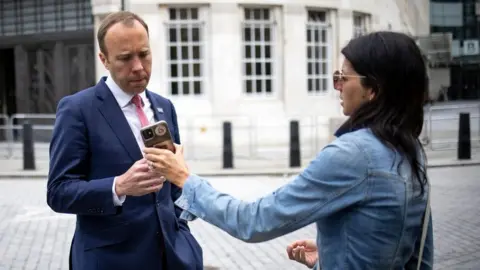 Getty Images Gina Coladangelo shows Matt Hancock a phone