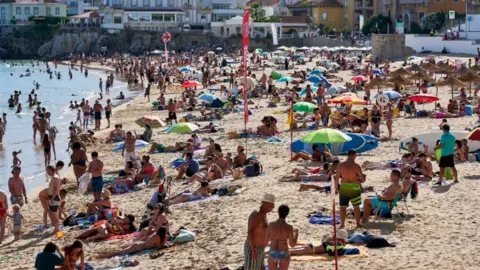 Getty Images Beachgoers crowd Praia da Duquesa in Cascais, Portugal