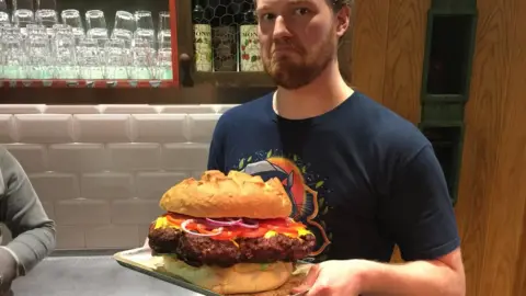 BBC Andrey Sidorov holding a giant 5kg burger.