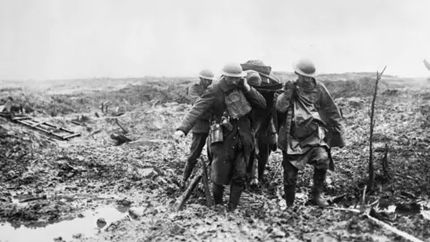 DCMS/PA A stretcher party struggle in the mud during the battle of Passchendaele