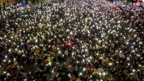 EPA Pro-democracy protesters hold up their mobile phones during rally against the state of emergency at Ratchaprasong shopping district in Bangkok, Thailand, 15 October 2020.